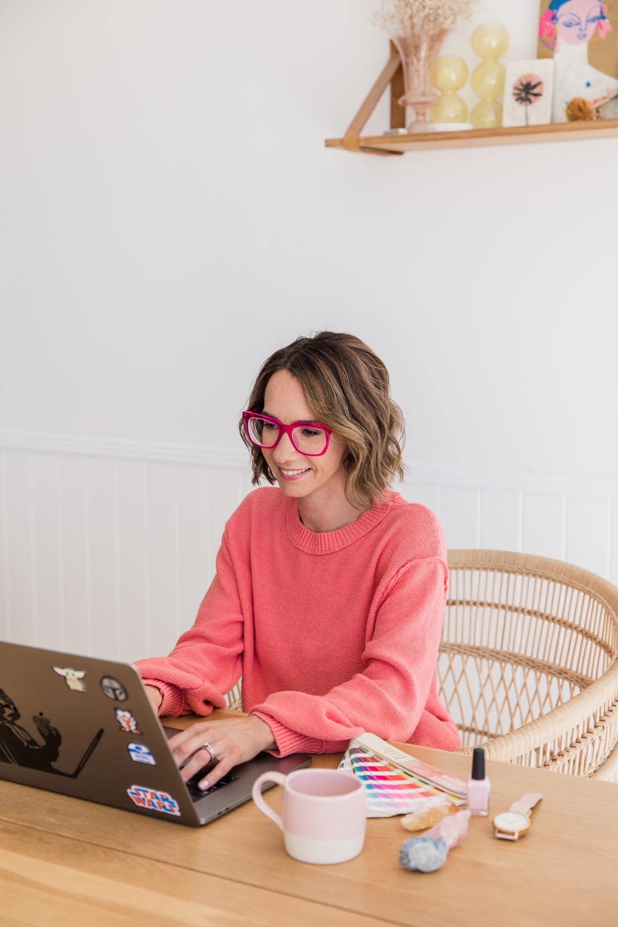 heidi wearing peach sweater design on laptop